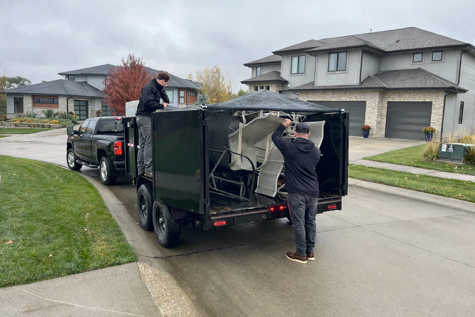 Crew loading a dump trailer during junk removal
